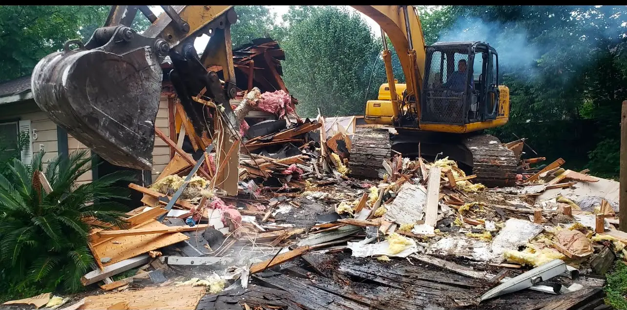 Excavator completing structural house demolition